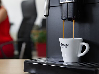 káva tečúca z kávovaru do espresso šálky s logom ebenica